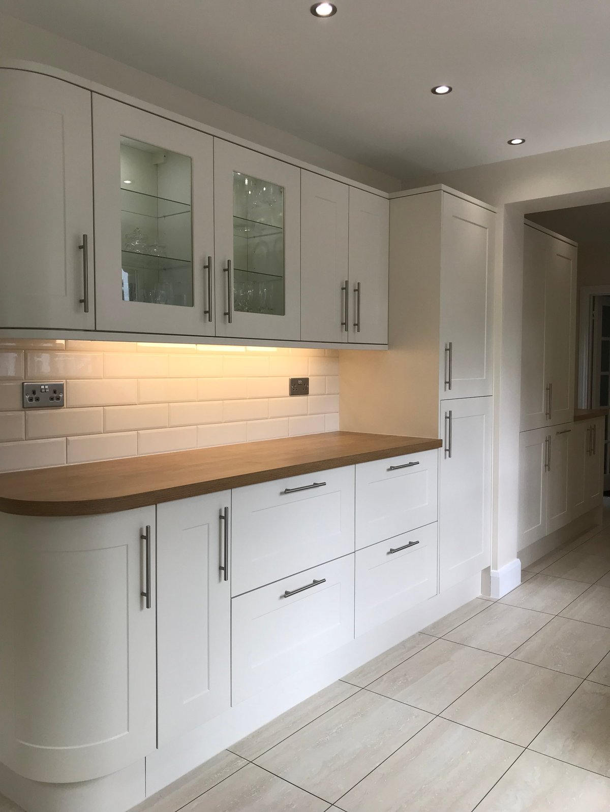 Modern white kitchen with glass-fronted cabinets