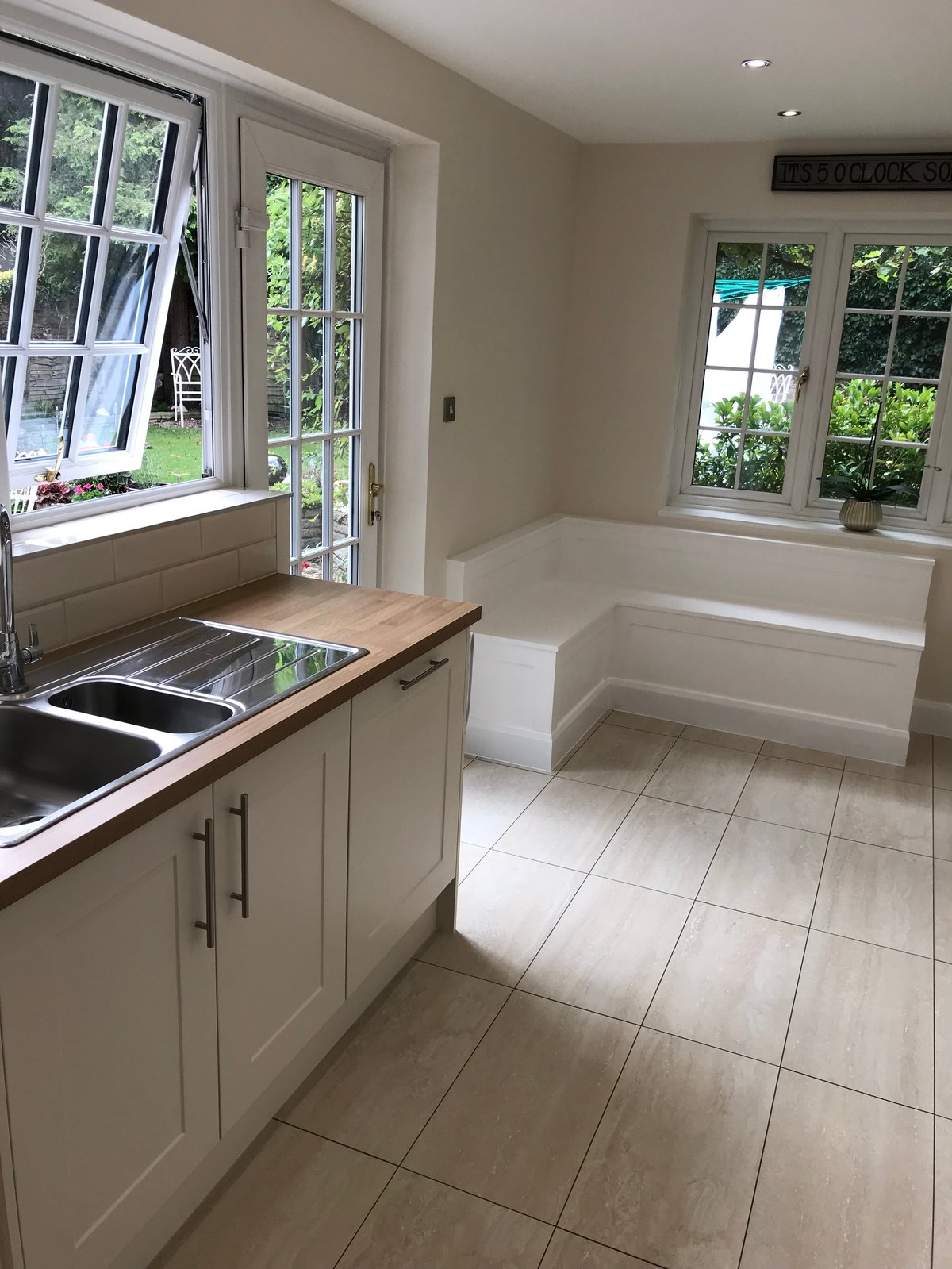 Modern kitchen with white cabinets overlooking garden