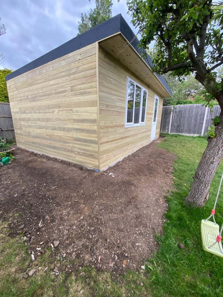 Modern wooden garden shed with dark roof and large window in backyard setting