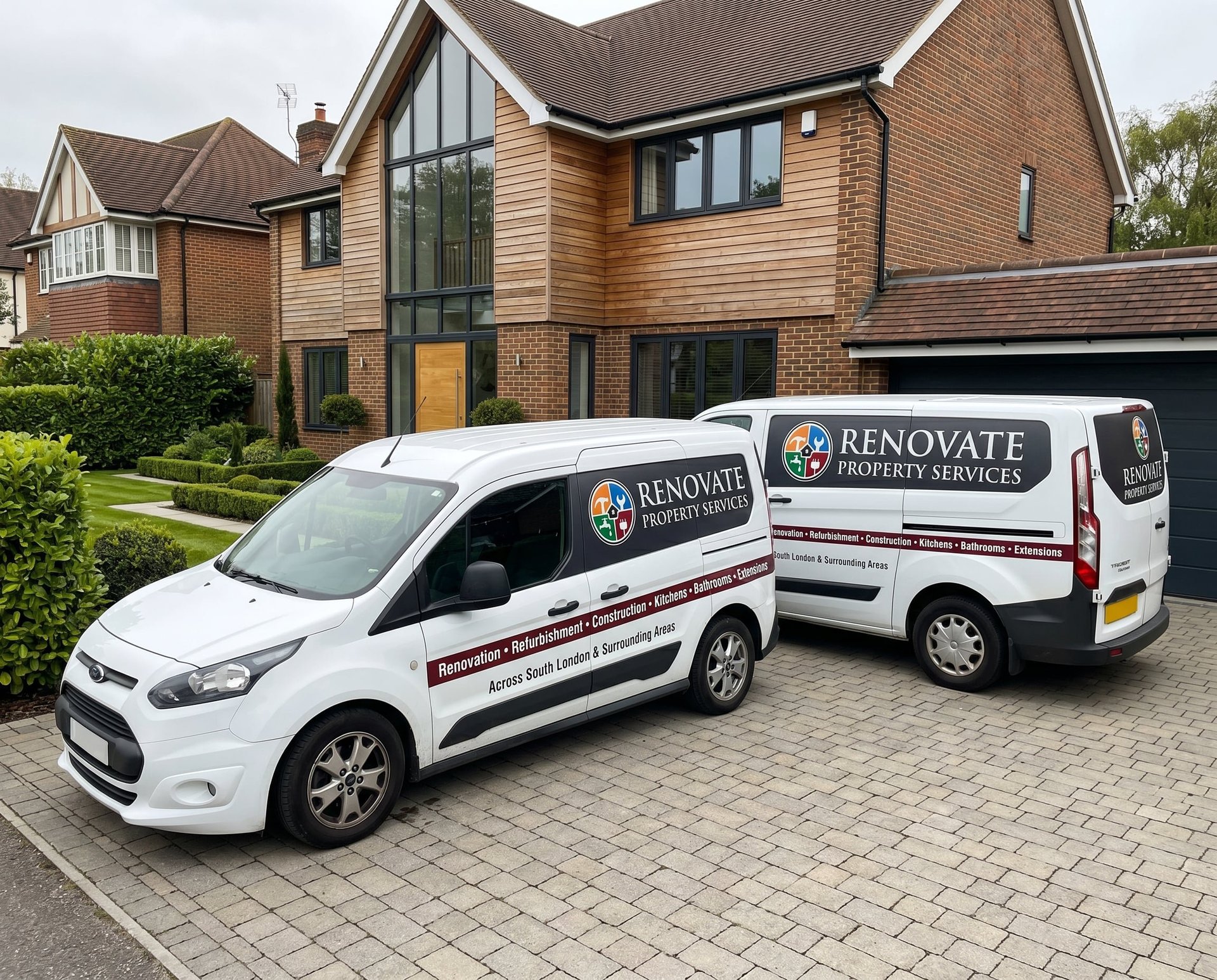 Two white Renovate Property Services vans parked in driveway of modern brick house with wooden cladding